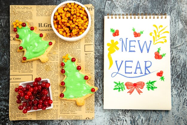 Vue de dessus de délicieux biscuits aux arbres avec des baies et une note de nouvel an