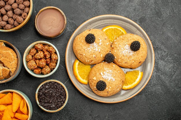 Vue De Dessus De Délicieux Biscuits Aux Noix Et Tranches D'orange Sur Fond Gris Foncé Biscuit Biscuit Thé Gâteau Sucré