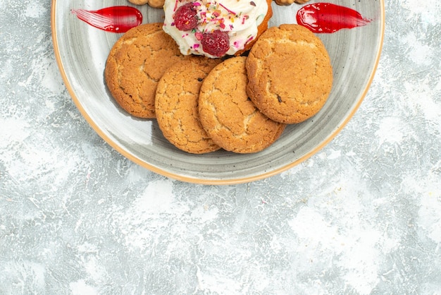 Vue de dessus de délicieux biscuits avec biscuits et gâteau à la crème sur un bureau blanc biscuits sucrés gâteau au thé au sucre