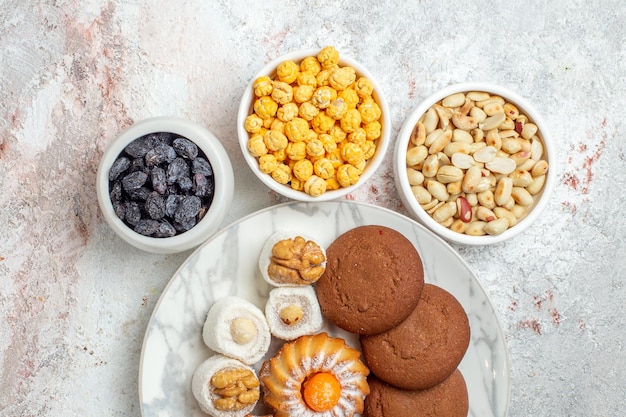 Vue de dessus de délicieux biscuits avec des bonbons et des noix sur fond blanc biscuit gâteau sucré écrou de biscuit