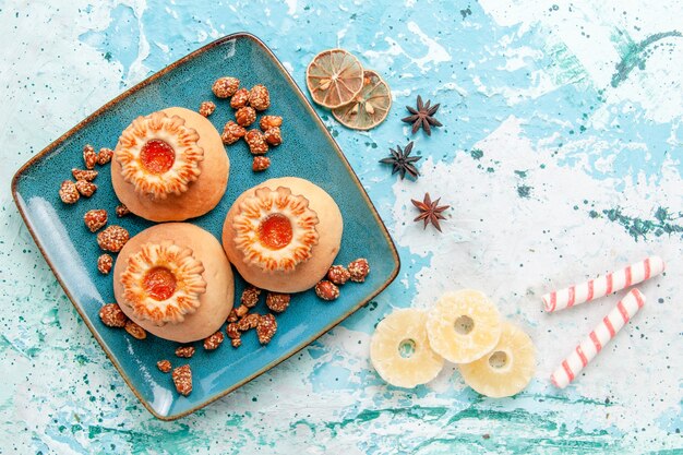 Vue de dessus de délicieux biscuits avec des bonbons sur la surface bleu clair biscuit biscuit couleur sucre sucré