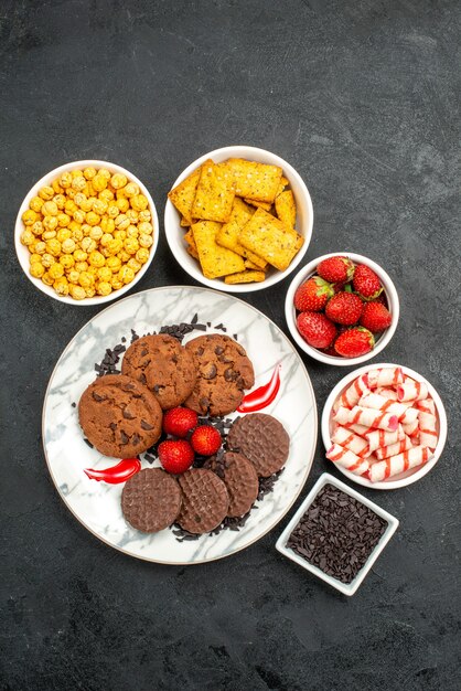 Vue de dessus délicieux biscuits choco avec différentes collations sur fond sombre thé biscuit sucré