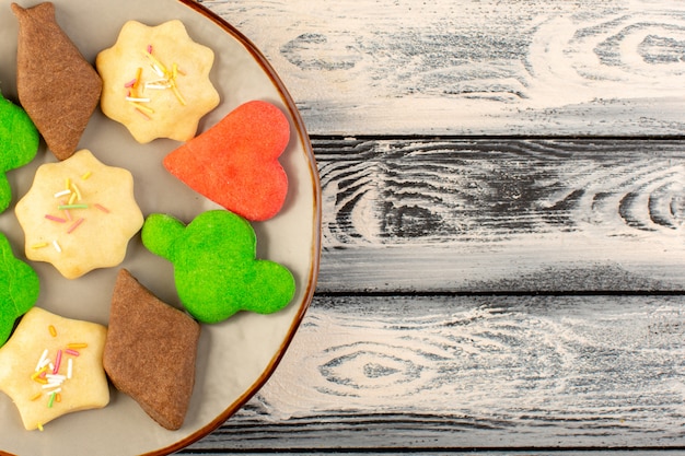 Vue De Dessus De Délicieux Biscuits Colorés Différents Formés à L'intérieur De La Plaque Ronde Sur Le Bureau Gris Biscuit Biscuit Thé Au Sucre Sucré