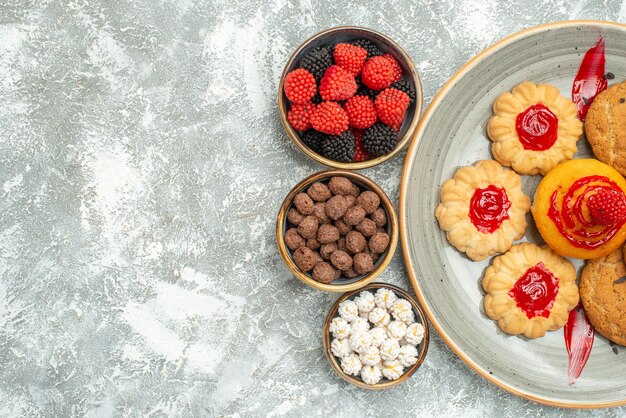 Vue de dessus délicieux biscuits de sable avec des biscuits et des bonbons sur blanc clair