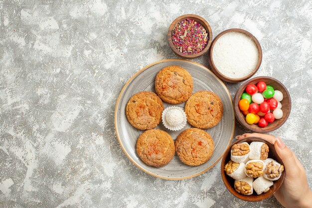 Vue de dessus de délicieux biscuits de sable avec des bonbons sur fond blanc