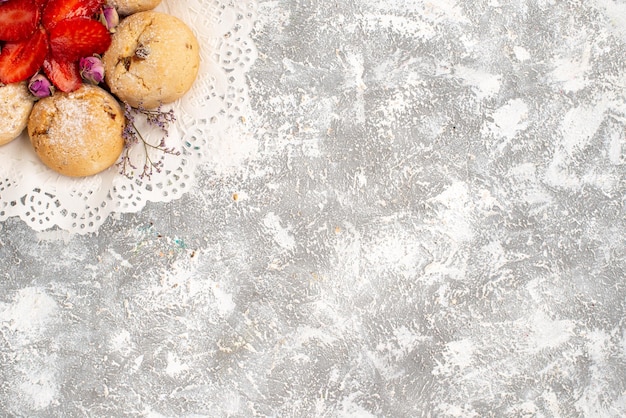 Photo gratuite vue de dessus de délicieux biscuits de sable avec des fraises fraîches sur la surface blanche