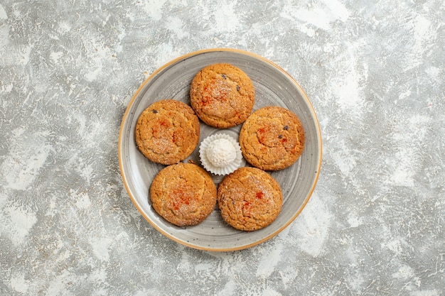 Vue de dessus de délicieux biscuits de sable à l'intérieur de la plaque sur fond blanc