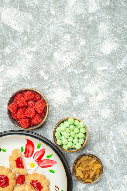 Vue de dessus délicieux biscuits sucrés avec des bonbons sur blanc