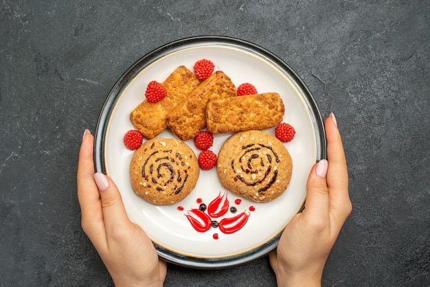 Vue de dessus délicieux biscuits sucrés à l'intérieur de la plaque sur fond gris biscuit gâteau au sucre sucré biscuit thé