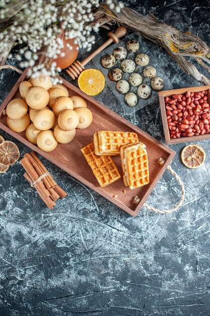 Vue de dessus de délicieux biscuits sucrés avec de petits gâteaux et des noix sur fond gris clair