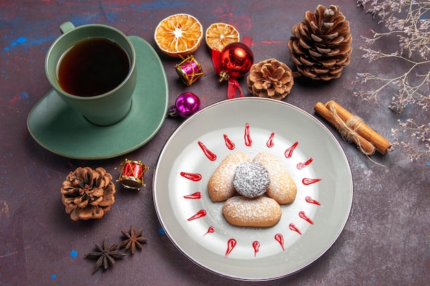 Vue de dessus de délicieux biscuits avec une tasse de thé sur fond noir