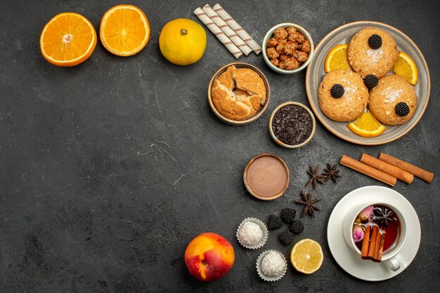 Vue de dessus de délicieux biscuits avec une tasse de thé sur un gâteau aux biscuits aux biscuits au thé noir