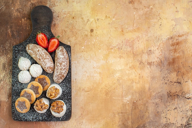 Photo gratuite vue de dessus de délicieux bonbons avec des cookies sur un bureau en bois