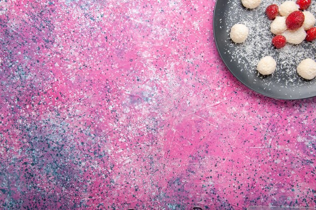 Vue de dessus de délicieux bonbons à la noix de coco boules sucrées sur la surface rose