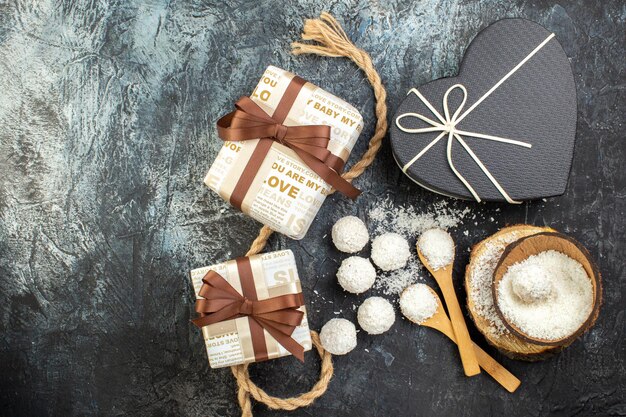 Vue de dessus de délicieux bonbons à la noix de coco avec des cadeaux sur fond gris amour couple goodie couleur douce saint valentin mariage thé cadeau