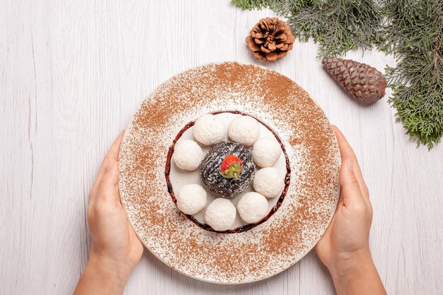 Vue de dessus de délicieux bonbons à la noix de coco avec gâteau au cacao sur blanc