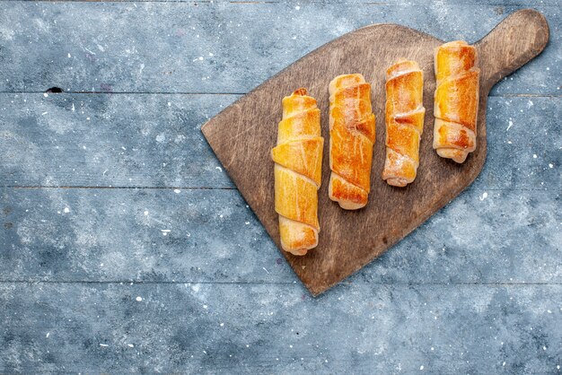 Vue de dessus de délicieux bracelets sucrés avec remplissage sur le fond gris pâtisserie au sucre sucré