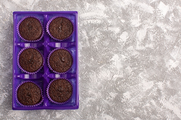 Vue de dessus de délicieux brownies au chocolat à l'intérieur de l'emballage violet sur la pâte de thé au chocolat gâteau de bureau léger cuire au four