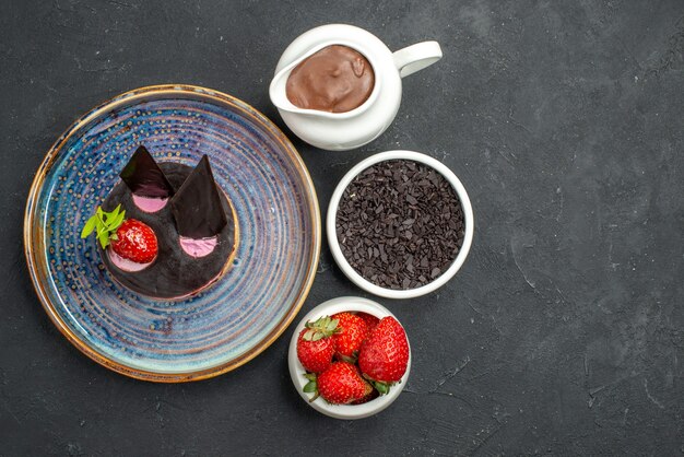 Vue de dessus délicieux cheesecake à la fraise et au chocolat sur des bols en assiette sur fond sombre isolé