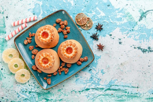 Vue de dessus de délicieux cookies avec des bonbons sur le fond bleu clair cookie biscuit couleur sucre sucré