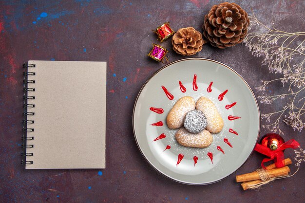 Photo gratuite vue de dessus de délicieux cookies avec des glaçages rouges sur fond noir