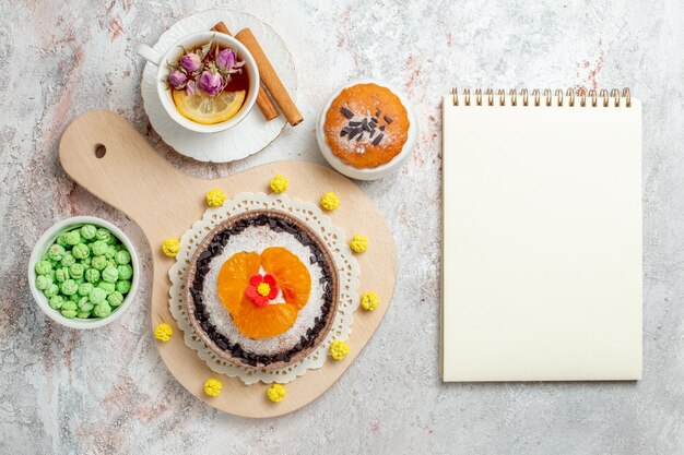 Vue de dessus délicieux dessert au chocolat avec une tasse de thé sur fond blanc crème biscuit gâteau dessert aux fruits