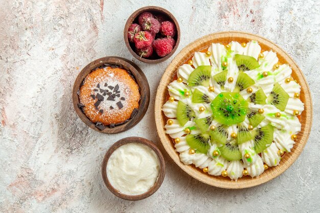 Vue de dessus délicieux dessert à la crème blanche sur fond blanc crème dessert gâteau aux fruits bonbons