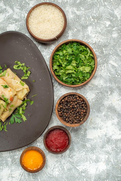 Photo gratuite vue de dessus délicieux dolma de chou se compose de viande hachée avec des verts sur fond blanc dîner de viande plat de nourriture de poivre