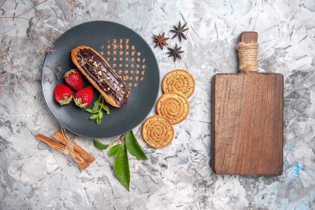 Vue de dessus de délicieux éclairs au chocolat avec des biscuits sur un biscuit de dessert au gâteau au biscuit au sol léger