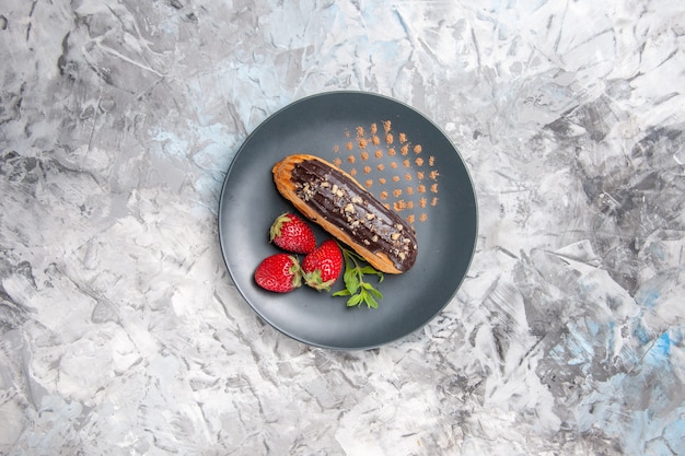 Vue de dessus de délicieux éclairs au chocolat avec des fraises sur le fruit du gâteau au dessert léger