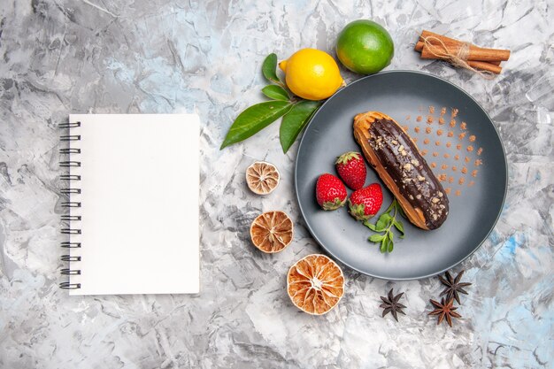 Vue de dessus de délicieux éclairs au chocolat avec des fruits sur des biscuits au dessert léger