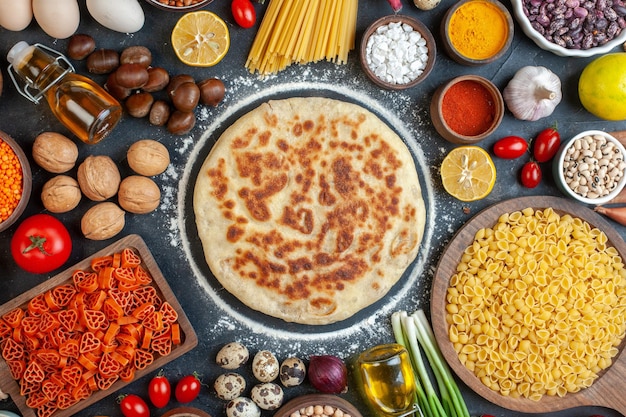 Vue de dessus délicieux flapjacks aux noix pâtes légumes et assaisonnements sur fond sombre pain pâtisserie gâteau pain couleur