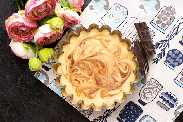 Une vue de dessus délicieux gâteau au café au chocolat sucré délicieux gâteau de boulangerie au sucre sucré avec des roses sur le bureau sombre