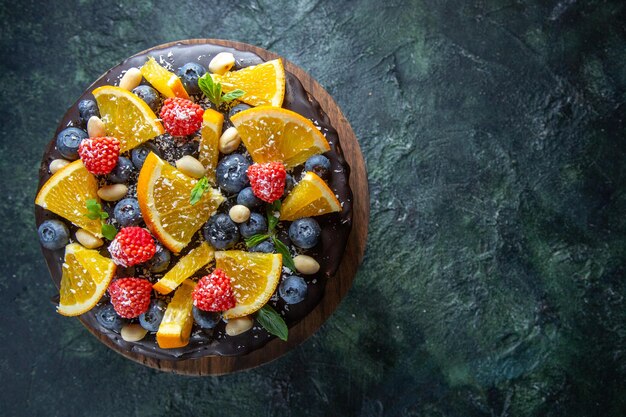 Vue de dessus délicieux gâteau au chocolat avec des fruits frais sur noir