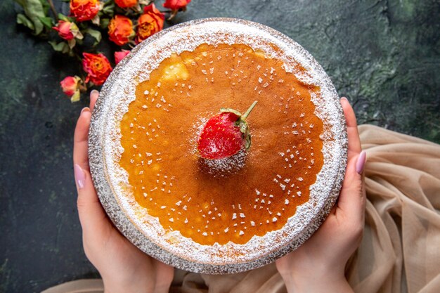 Vue de dessus délicieux gâteau au miel avec du sucre en poudre sur une surface sombre de planche de bois ronde