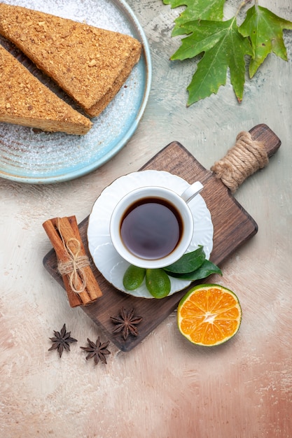 Vue de dessus d'un délicieux gâteau au miel avec une tasse de thé à la lumière