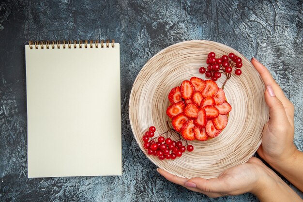 Vue de dessus délicieux gâteau aux fraises aux fruits rouges sur fond sombre