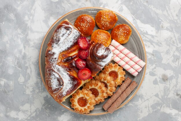 Vue de dessus délicieux gâteau aux fraises avec des biscuits et des petits gâteaux sur la surface blanche biscuit gâteau au sucre biscuit tarte sucrée