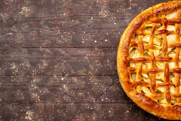 Une vue de dessus délicieux gâteau aux pommes en forme ronde sur le fond sombre gâteau biscuit sucre thé aux fruits