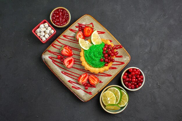 Vue de dessus délicieux gâteau crémeux aux fraises sur le fond sombre thé dessert au sucre sucré