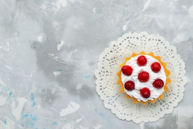 Vue de dessus délicieux gâteau crémeux à la crème et fruits rouges sur la surface grise biscuit gâteau sucré sucre fruit