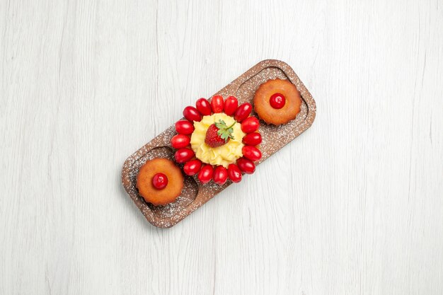 Vue de dessus délicieux gâteau crémeux avec des gâteaux sur un bureau blanc biscuits gâteau biscuit thé