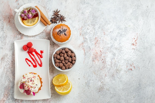 Vue De Dessus Délicieux Gâteau Crémeux Avec Tasse De Thé Et Tranches De Citron Sur Fond Blanc Biscuit Crème Gâteau Thé Bonbons