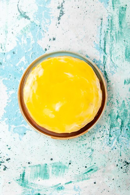 Vue de dessus délicieux gâteau avec du sirop jaune sur la surface bleue du gâteau biscuit cuire le thé au sucre biscuit sucré