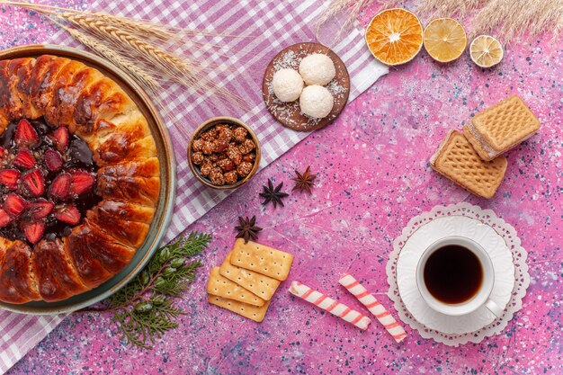 Vue de dessus délicieux gâteau fruité tarte aux fraises avec du thé et des gaufres sur rose