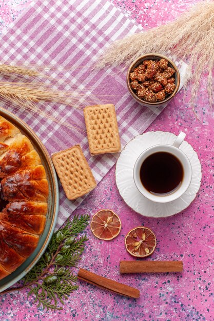 Vue de dessus délicieux gâteau fruité tarte aux fraises avec tasse de thé sur le rose