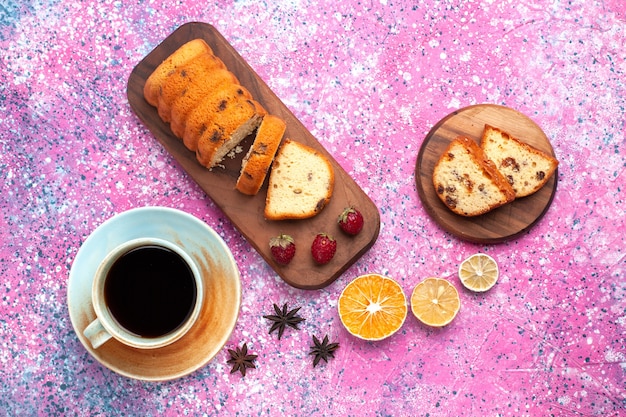 Vue de dessus délicieux gâteau sucré et délicieux tranché avec une tasse de thé chaud sur un bureau rose.