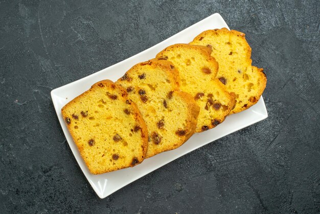 Vue de dessus délicieux gâteau en tranches à l'intérieur de la plaque sur la surface sombre gâteau sucré biscuit thé tarte thé