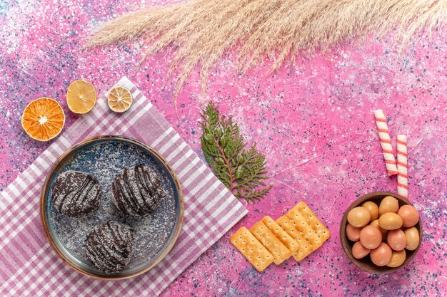 Vue de dessus de délicieux gâteaux au chocolat avec cracker sur rose