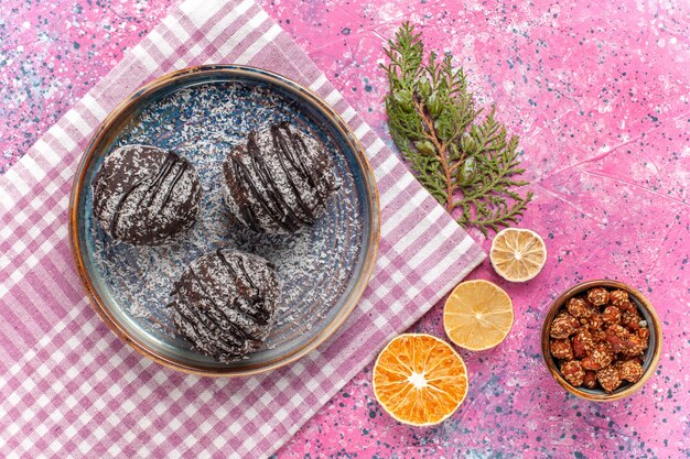 Vue de dessus de délicieux gâteaux au chocolat avec du citron sur rose